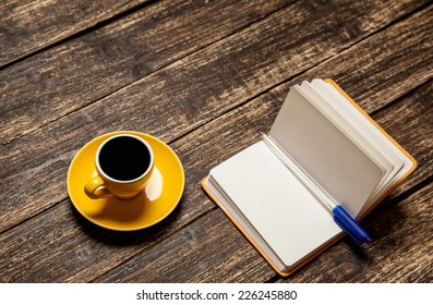 Coffee cup and notebook on a table.