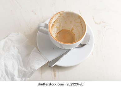 Coffee Cup On A Light Marble Top. The Dregs In The Cup, With Spots