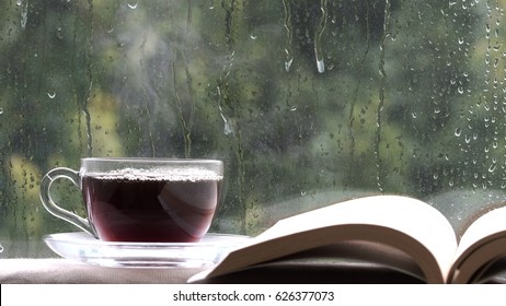 Coffee cup on a rainy day window and book