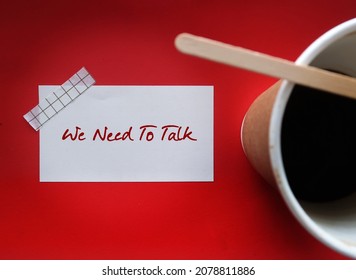 Coffee cup on red background with note written WE NEED TO TALK, means there is a serious problem that needs to be discussed, partners serious conversation generally followed by relationship ending - Shutterstock ID 2078811886