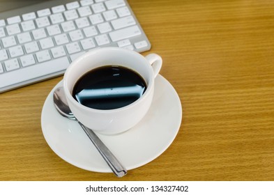 Coffee Cup on the Table with Computer Keyboard for Business Concept.
