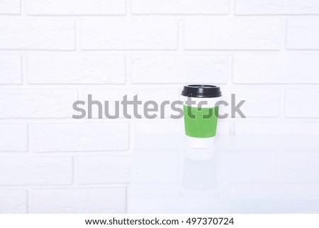 Coffee cup on white table in office. Selective focus and copy space