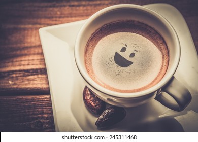 Coffee Cup On A Wooden Table With Smiley In It