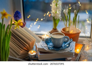Coffee cup, open book, beautiful flowers, sparkle candles on window with bokeh. Reading and cup of coffee. Concept hygge warm and cozy home interior
 - Powered by Shutterstock