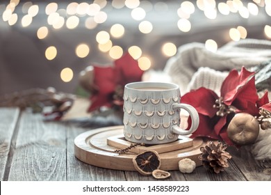 Coffee Cup Over Christmas Lights Bokeh In Home On Wooden Table With Flowers On A Background And Decorations. Winter Mood, Holiday Decoration, Magic Christmas.