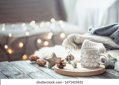 Coffee Cup Over Christmas Lights Bokeh In Home On Wooden Table With Sweater On A Background And Decorations. Winter Mood, Holiday Decoration, Magic Christmas.