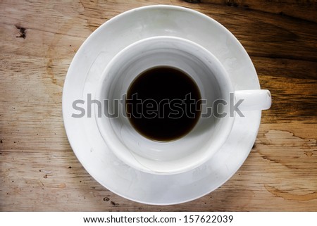 Coffee cup over wood table background. Dregs in the bottom of the cup.