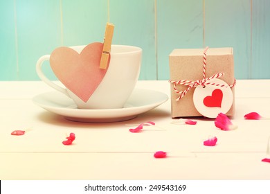 Coffee cup with pink heart tag and a small gift box - Powered by Shutterstock