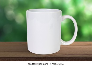 
 Coffee Cup Resting On Rustic Wood Tabletop Outside With Soft Bokeh Nature Background.