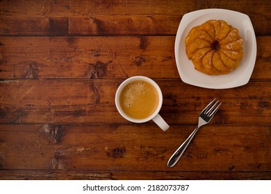 Coffee Cup With Round Lemon Cake On White Plate And Dessert Fork On Brown Wooden Table. Top View. Copy Space.