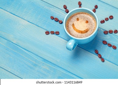 Coffee Cup With Smiley Face On Blue Wooden Table