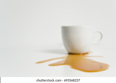 Coffee cup and spilled coffee. white background close up.