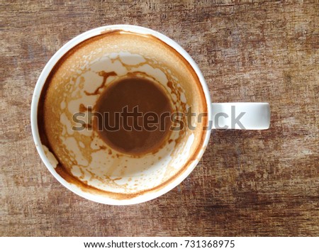 Coffee cup with coffee stains have not washed the cup placed on wooden