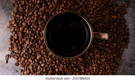 Coffee cup surrounded by coffee beans