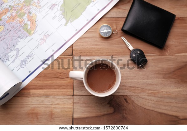 coffee cup and travel gear on wooden table\
with copy space\
background