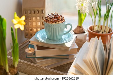 Coffee Cup With Whipped Cream, Spring Flowers And Open Book On Window Sill. Concept Warm And Cozy Home, Hygge, Reading Books, Rest And Comfort, Springtime
