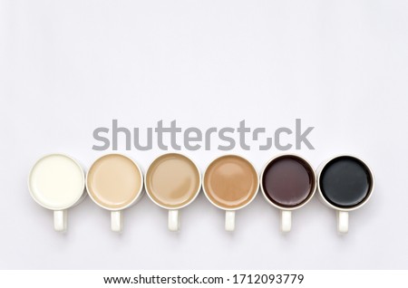 Coffee cups arranged in a creative way creating a gradient colour palette effect on white background Foto stock © 