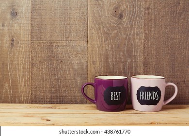 Coffee cups on wooden table with chalkboard sign and best friends text. Friendship day celebration background - Shutterstock ID 438761770