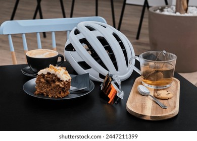 Coffee cycling ride. Cyclist enjoying coffee in the cafe after riding. Cup coffee and cycling helmet with sunglasses on the table. - Powered by Shutterstock