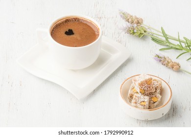 Coffee And Delight, A Cup Of Coffee And Turkish Delight On Wooden Table Or Background Decorated With Flowers. Traditional Turkish Sweet Or Dessert And Drink Famous In Turkey. Heart Shaped Frothy Drink