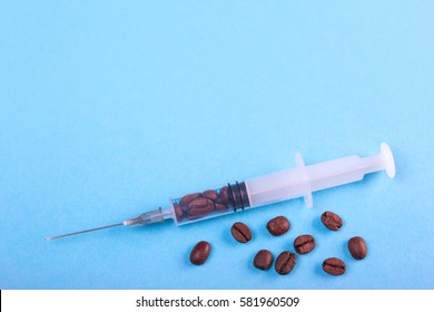 Coffee drug dependence on coffee, with a dose syringe. On a blue background