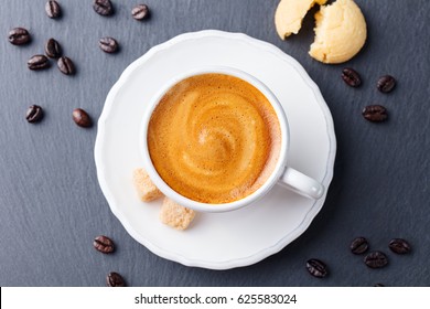 Coffee Espresso In White Cup On Black Slate Background. Close Up. Top View.