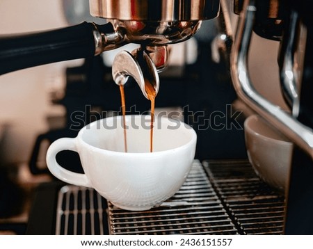 Coffee extraction from the coffee machine with a portafilter pouring coffee into a cup,Espresso poruing from coffee machine 