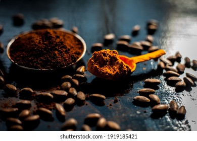 Coffee Face Mask For Treating Oily Skin And For Skin Whitening On A Black Colored Shiny Surface Consisting Of Some Coffee Beans Powder, Turmeric Powder, And Yogurt.