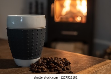 Coffee In Front Of A Woodstove With Fresh Beans On Table. Fire And Coffee