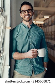 Coffee Is The Fuel I Need To Keep Going. Cropped Portrait Of A Handsome Young Businessman Smiling While Holding A Cup Of Coffee In An Office.