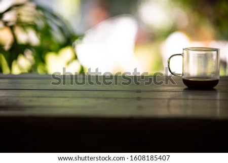 Coffee glasses cup with coffee stains stuck on them, then after drinking it on wooden table in bokeh blurred green garden background, Close up shot, Selective focus