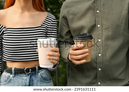Coffee to go. Couple with paper cups outdoors, closeup