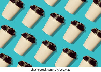 Coffee to go regular pattern made of photo on a turquoise background. Kraft paper cups with black lids and natural hard shadows. Lifestyle take away hot drinks concept. Trendy flatlay, top view.