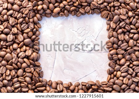 Coffee grains in the bottom of the image on a gently light background