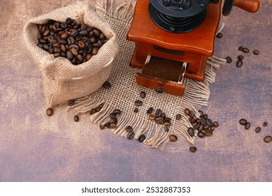 Coffee grinder with coffee beans and old rustic wooden table background