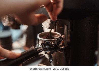 Coffee grinder grinds fresh coffee beans into a portafilter for  espresso machine. Barista grind coffee bean with grinder machine. Selective focus. - Powered by Shutterstock