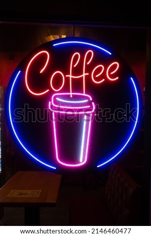 Coffee inscription glows neon sign close-up.