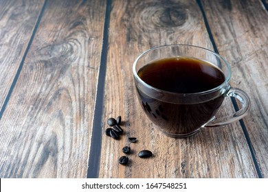 Coffee Inside Clear Glass Over Wooden Background.