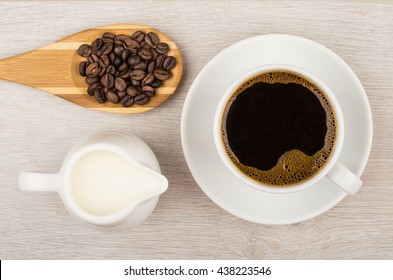 Coffee, Jug Milk And Wooden Spoon With Coffee Beans On Table. Top View