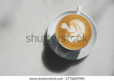 Coffee with latte art on table at daytime