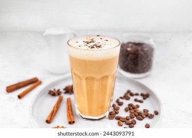 Coffee latte in glass with cinnamon, spices and roasted coffee beans. Creamy coffee with milk. Coffee drink recipe.  - Powered by Shutterstock