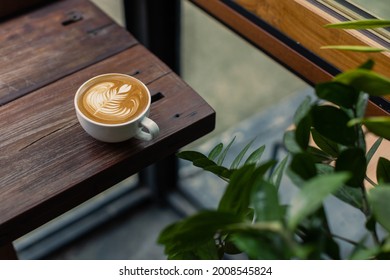 coffee latte on wood bar with coffee shop background