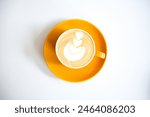 Coffee Latte with yellow ceramic cup, white background, decorated with leaf look a like latte art