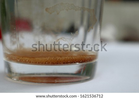 Coffee left a glass bottom on a white table, cool outside atmosphere.