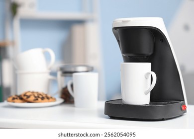 Coffee machine with cup on table in office, closeup