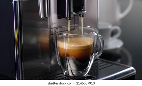 Coffee machine filling a cup with expresso. Transparent mug in automated coffeemaker machine. Beverage drink for breakfast - Shutterstock ID 2146587913