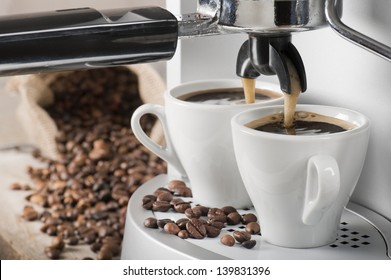 coffee machine makes two coffee with coffee beans on background