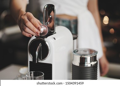 coffee machine,women holding coffee capsules and put in espresso machine with empty cup of coffee at kitchen .                               