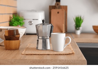 Coffee maker and mug on table in kitchen, closeup