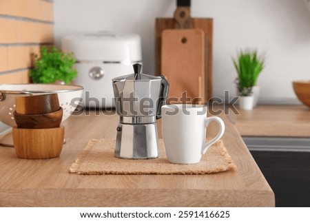 Coffee maker and mug on table in kitchen, closeup